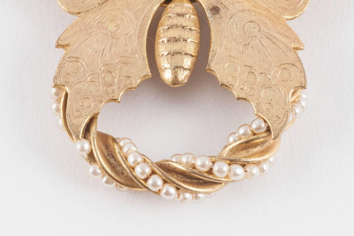 This such a fun quirky brooch, full of Miriam Haskell signature details. The gilding is a beautiful soft pale gold, and the pearl encrusted swag adds a bit of richness to the design. 
Miriam Haskell was born in 1899, opening her first boutique near