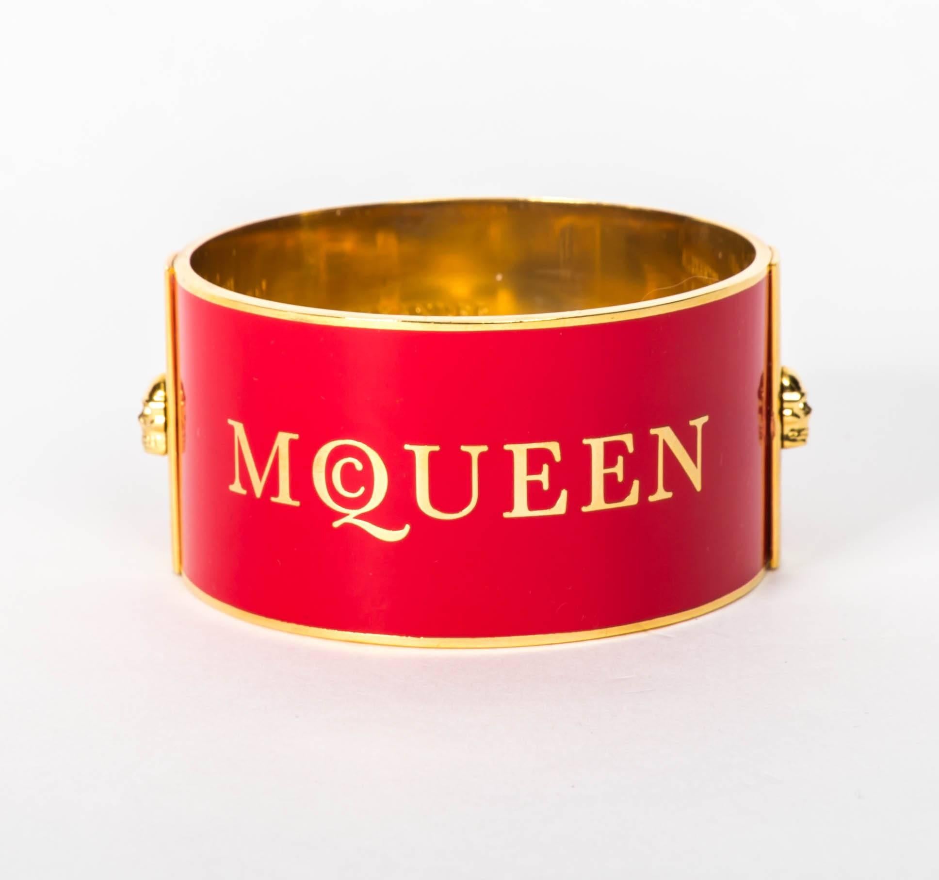 Alexander McQueen Red Enamel on Gold Metal Cuff / Bracelet
McQueen's Iconic skulls enhance each side of this fabulous cuff
This Cuff slips on the wrist and is 2 1/2 inches in diameter and 8 3/4 inches in circumference