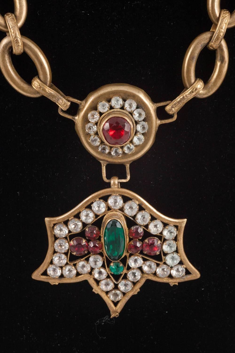 This is a very strong look. The necklace has been put together and comes from the costume department of a French theatre. It is brass with a lovely pendant, featuring closed backed paste stones. 