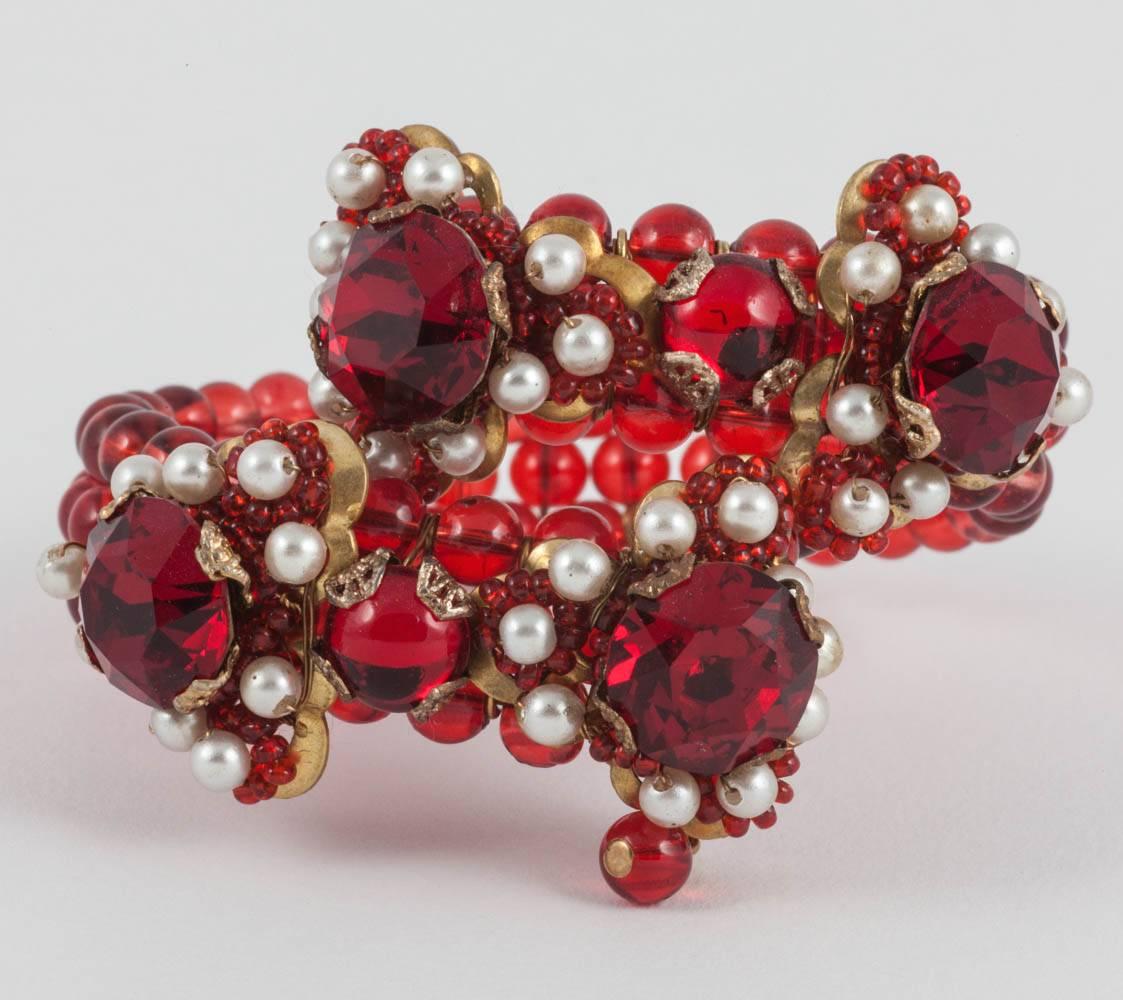 This bold bracelet, in bright scarlet, has lovely pearl accents and huge ruby paste cut and cabochon glass stones. It is hand beaded in the manner of Miriam Haskell, but does not have any maker's marks.  Fun and easy to wear with knitwear. or for