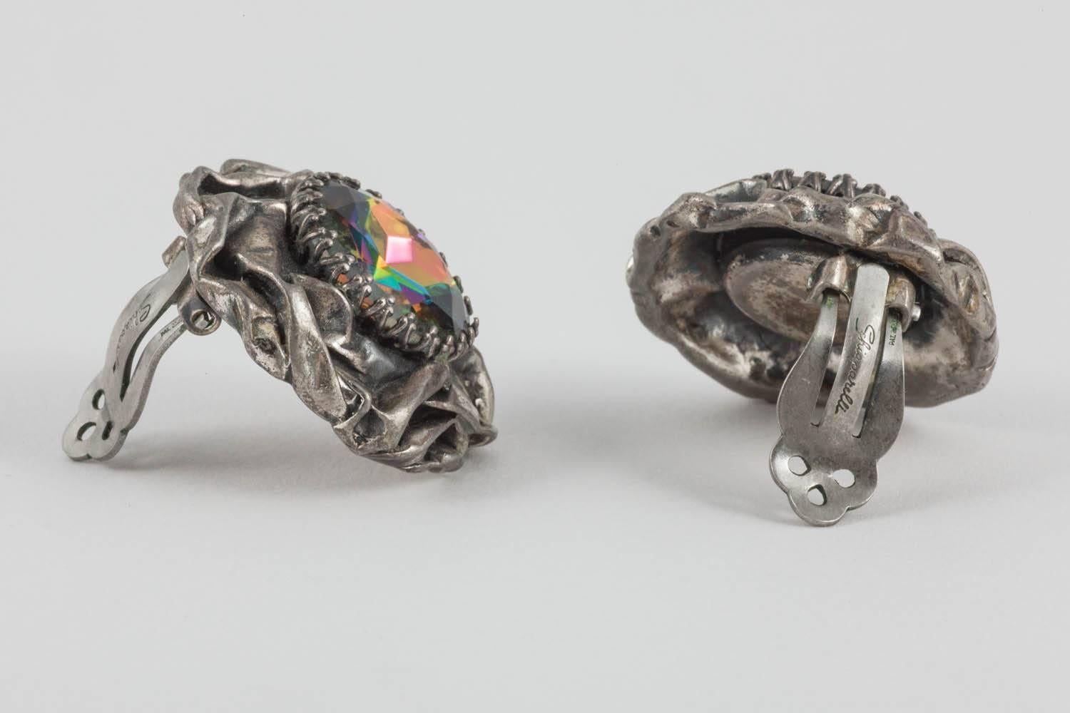 Typical of Schiaparelli's surrealist sensibility, these bold clip on earrings feature silvered metal that looks as if it were a screwed up piece of paper set with a wonderfully bright multicoloured 'Rivoli' glass central stone. This is a very
