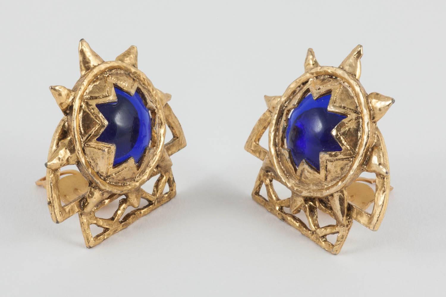 These classic Claire Deve earrings have a star shaped window of gilt metal from which a deep blue glass cabochon peeps out. They are well balanced and comfortable clip- ons ideal for day or night. 