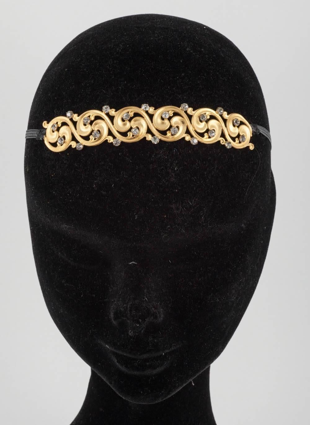 This lovely slightly curved small headdress is early Victorian. It has a curling scroll work of gilt metal and old paste accents that have a slight grey tint. It has rings at each end to secure it to the wearer's head. I have put a new small black