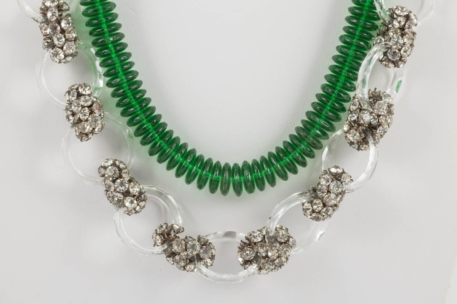 A magnificent long beaded necklace, made from 'doughnut' shaped emerald green glass discs, faceted clear glass rings, of two sizes, and clear paste clusters. With an engraved barrel clasp to the rear (marked 'Made in France'), the emerald discs form