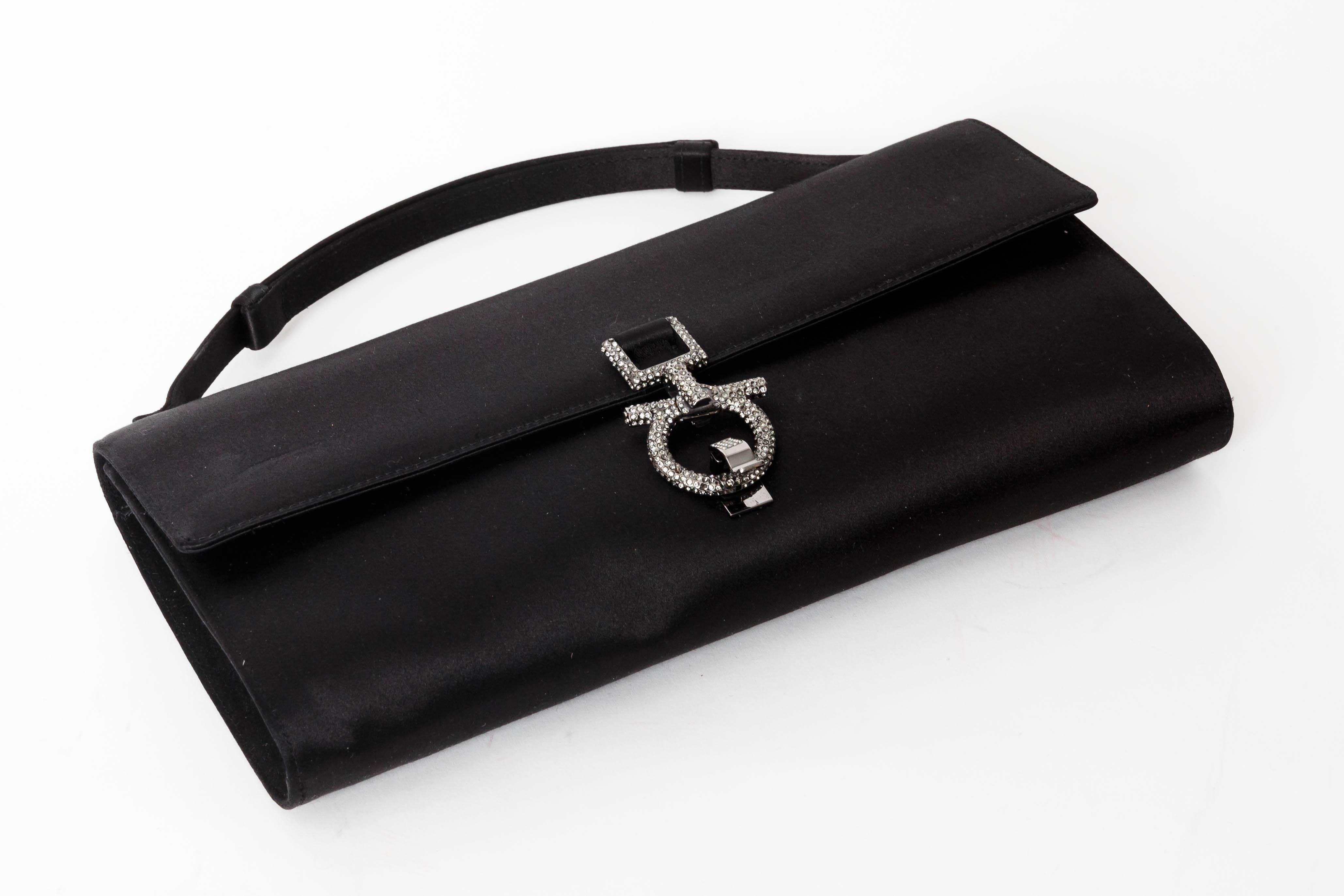 Elegant Ferragamo Clutch in Black Silk with Crystal Gancini Closure
There are a couple of indentations in the silk. We believe these could be steamed out but will leave that to the new owner.