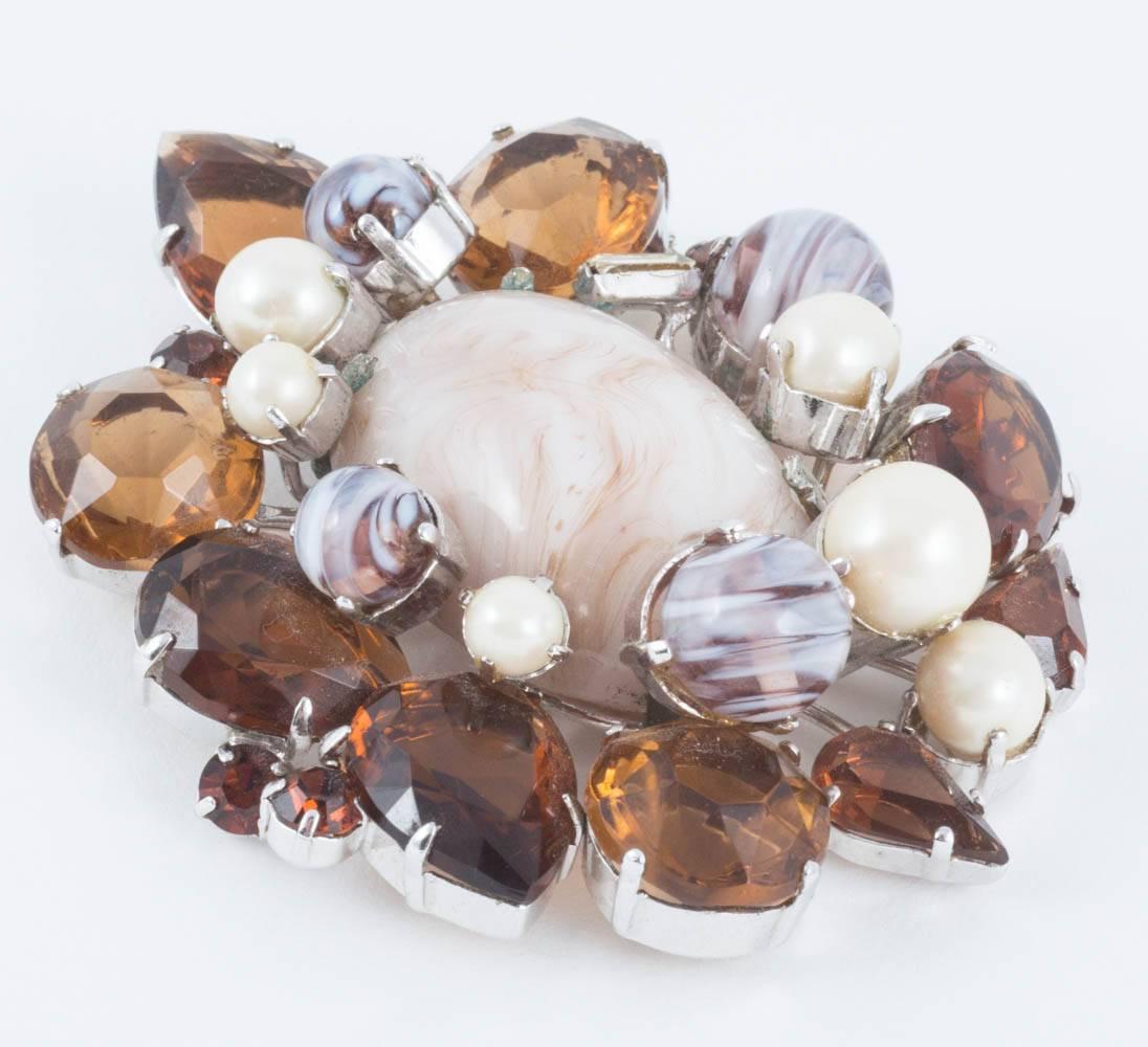 A striking combination of smokey quartz coloured  pastes of mixed shapes, specially  made marbled cream and brown stones mingled with paste pearls go to making this an iconic piece, made by Henkel and Grosse for Christian Dior, in the year 1960,