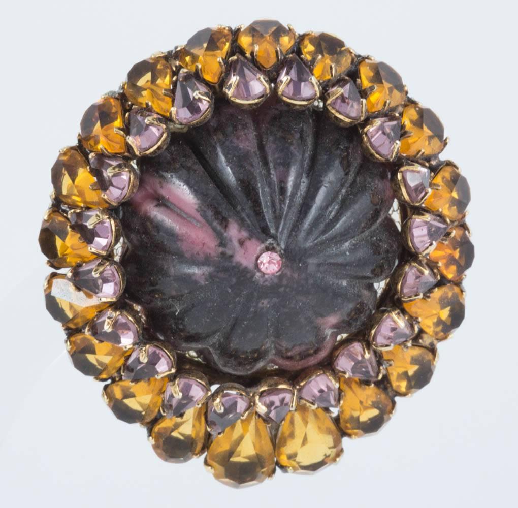 These are a really vivid colour palette from Iradj Moini. A central carved Rhodenite centre stone is surrounded by pale pink and citrine coloured paste. 
The citrines are allowed to glow because they are open set at the bottom, where they would hang