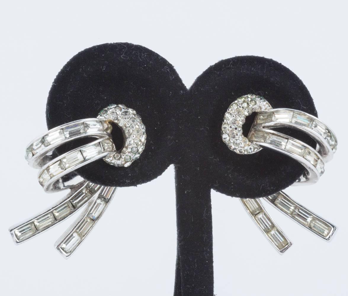 Very elegant paste earrings from Marcel Boucher, in clear paste and clear paste baguettes set in rhodium plated metal. Both earrings sit on the ear as if 'split' in two, with the front of the earring in front of the lobe, and the back part sitting