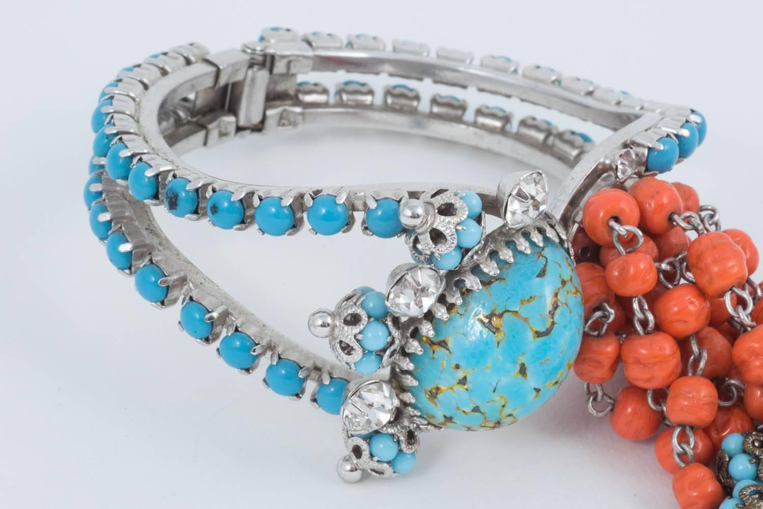 A perfect and extremely frivolous 1950s cocktail bracelet featuring lovely art glass 'stones' to imitate coral and turquoise with a central huge duck egg art glass cabochon. 
This bracelet is in the clamper style and still has its spring very much