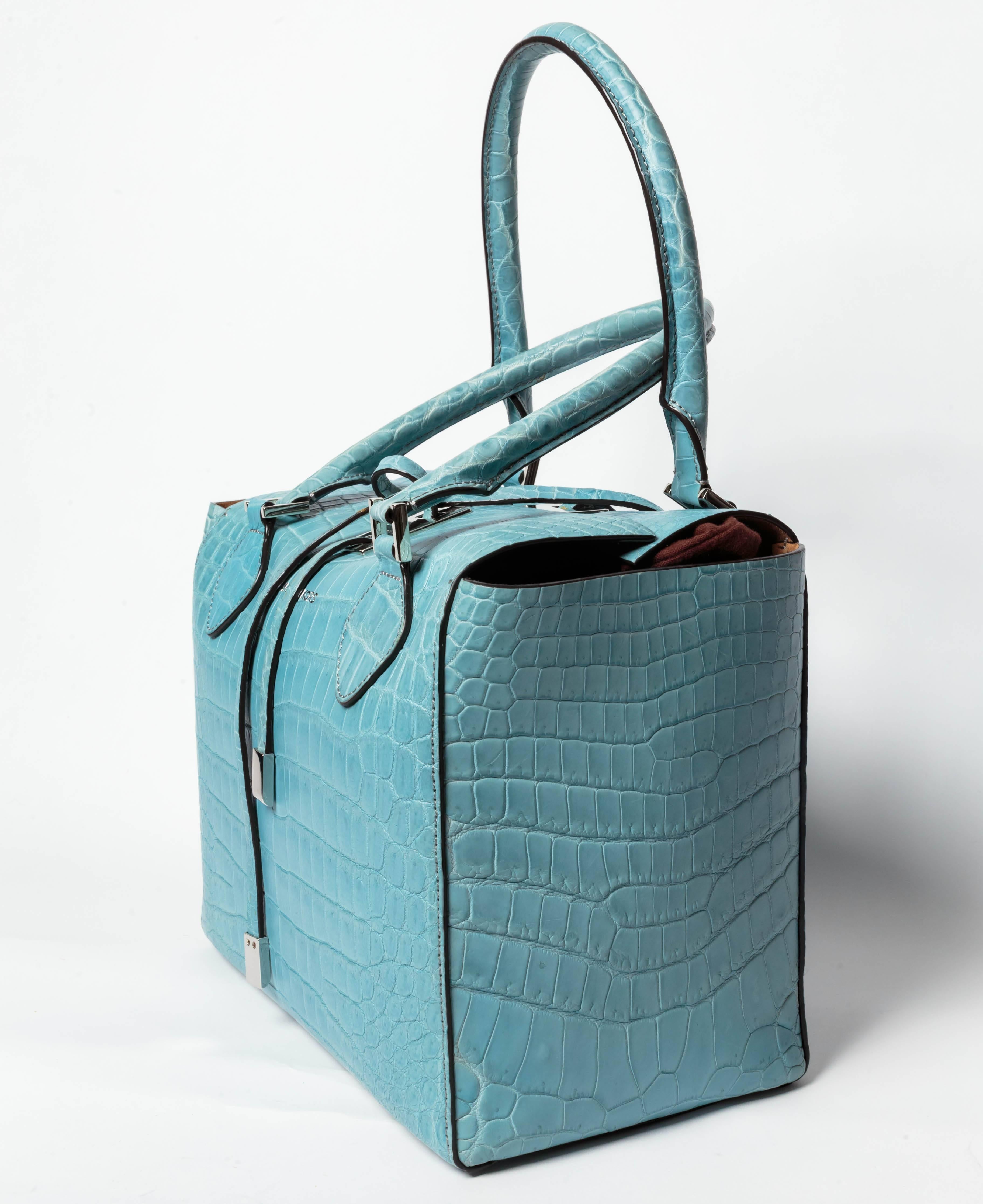Limited Edition ( # 6/100 ) Ice Blue Crocodile Michael Kors Medium Miranda Tote.
Silver tone hardware, dual rolled top handles, tan suede interior, three interior pockets; one with zip closure and turn-lock closure.
Includes original