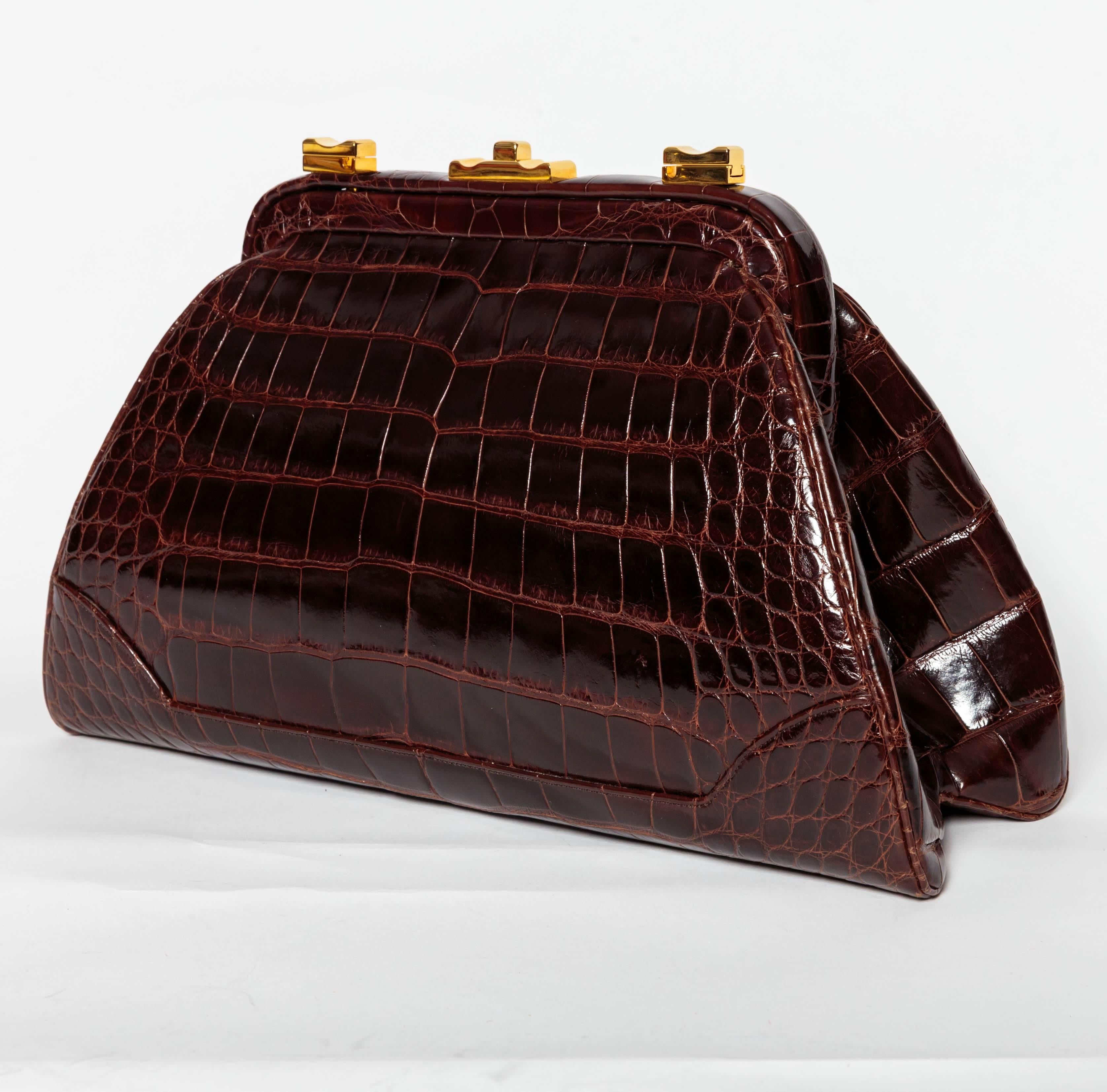 Stunning Judith Leiber dark brown alligator clutch with gold hardware.
A detachable alligator shoulder strap can be easily added or removed to make this bag more casual.
Condition is excellent.
Two interior pockets, one with iconic handbag zip pull,
