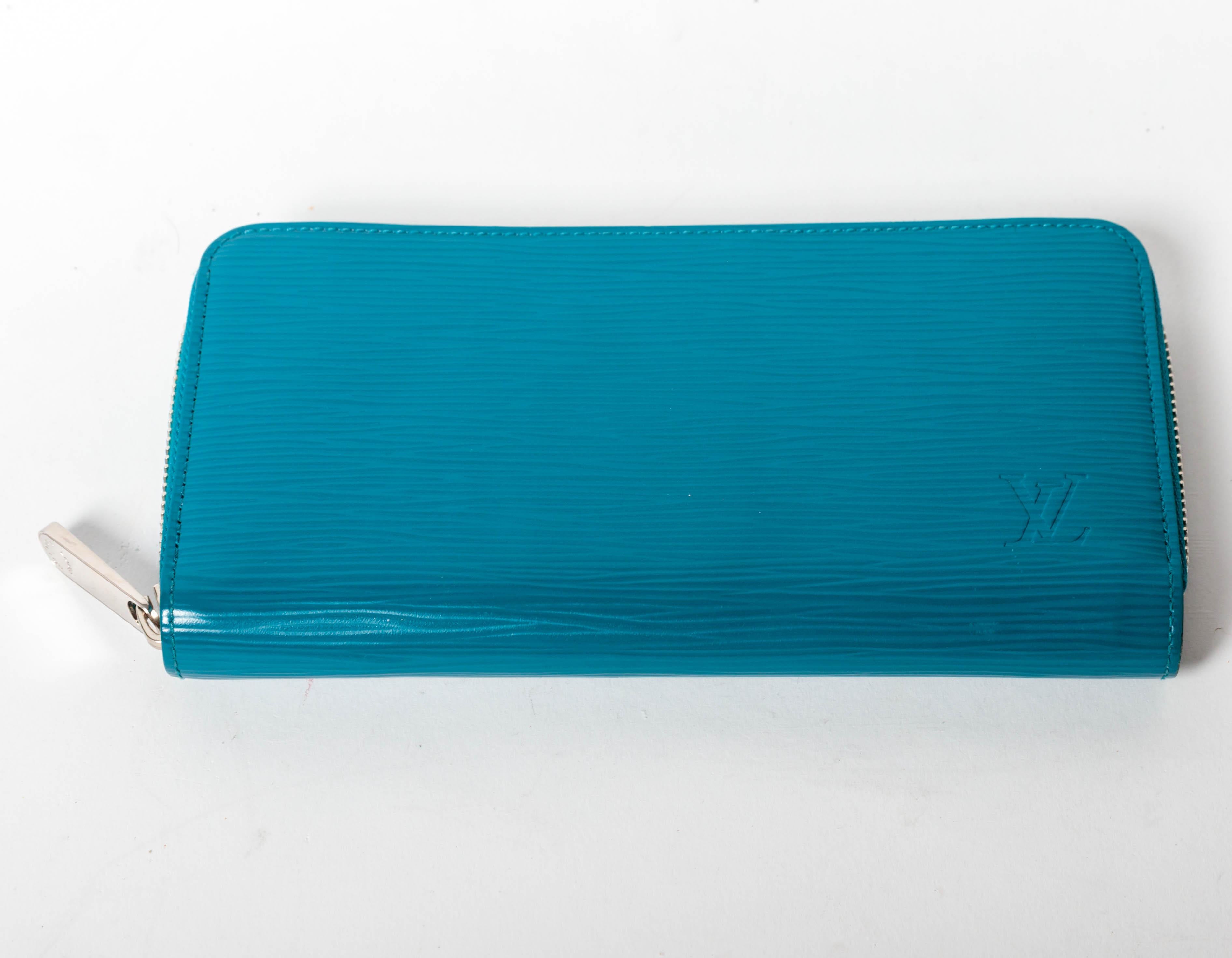 Cyan Epi leather Louis Vuitton Zippy Organizer wallet with silver hardware, dual interior pockets, one with zip closure.
Dual bill compartments, 8 card slots and zip around closure.
Condition is excellent.