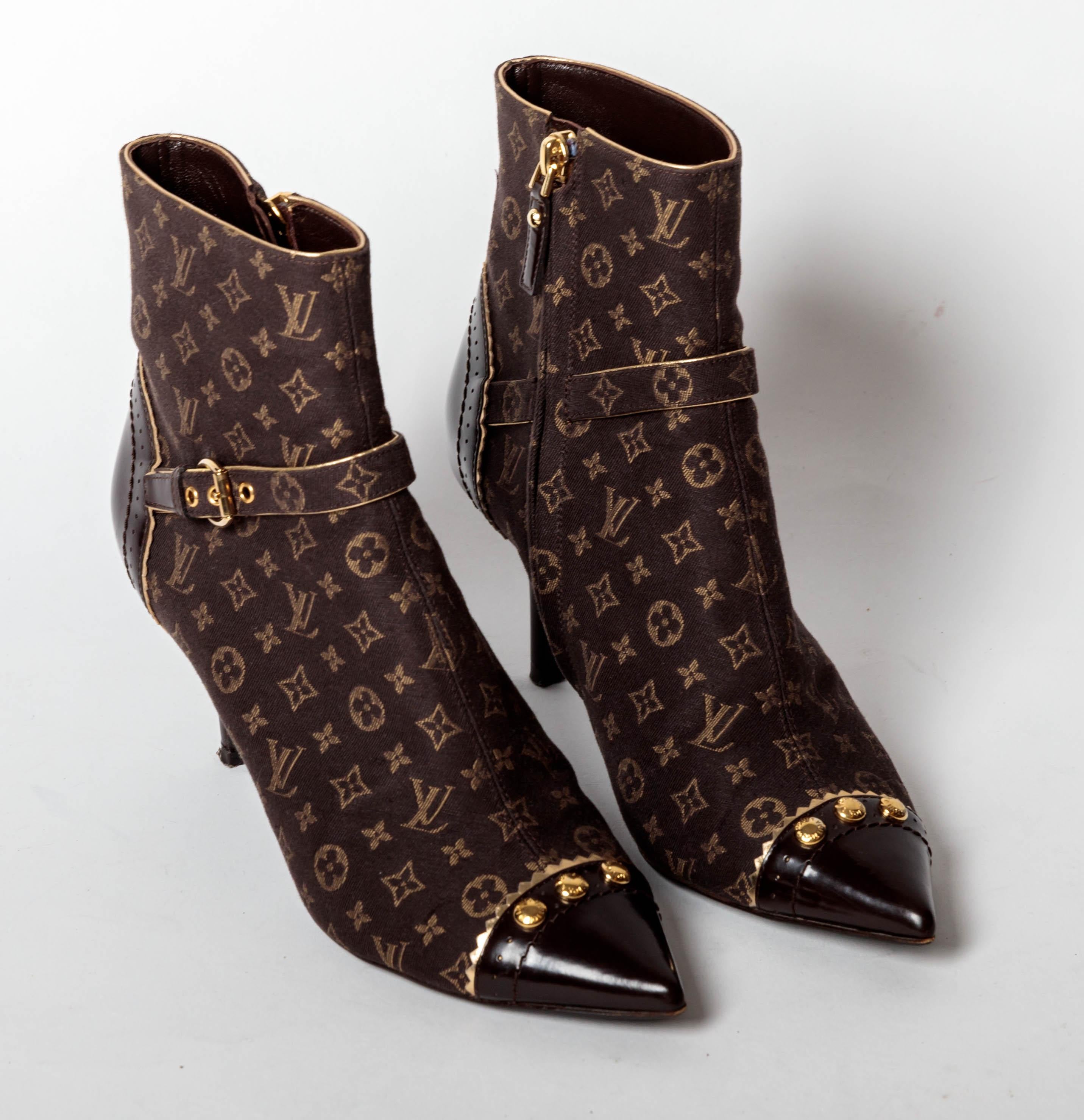 Absolutely adorable Louis Vuitton monogram booties with gold trim.
Worn just a couple of times, these canvas monogram booties have leather pointed toe detail with gold studs, leather heel detail with gold trim and a buckle strap across the top of