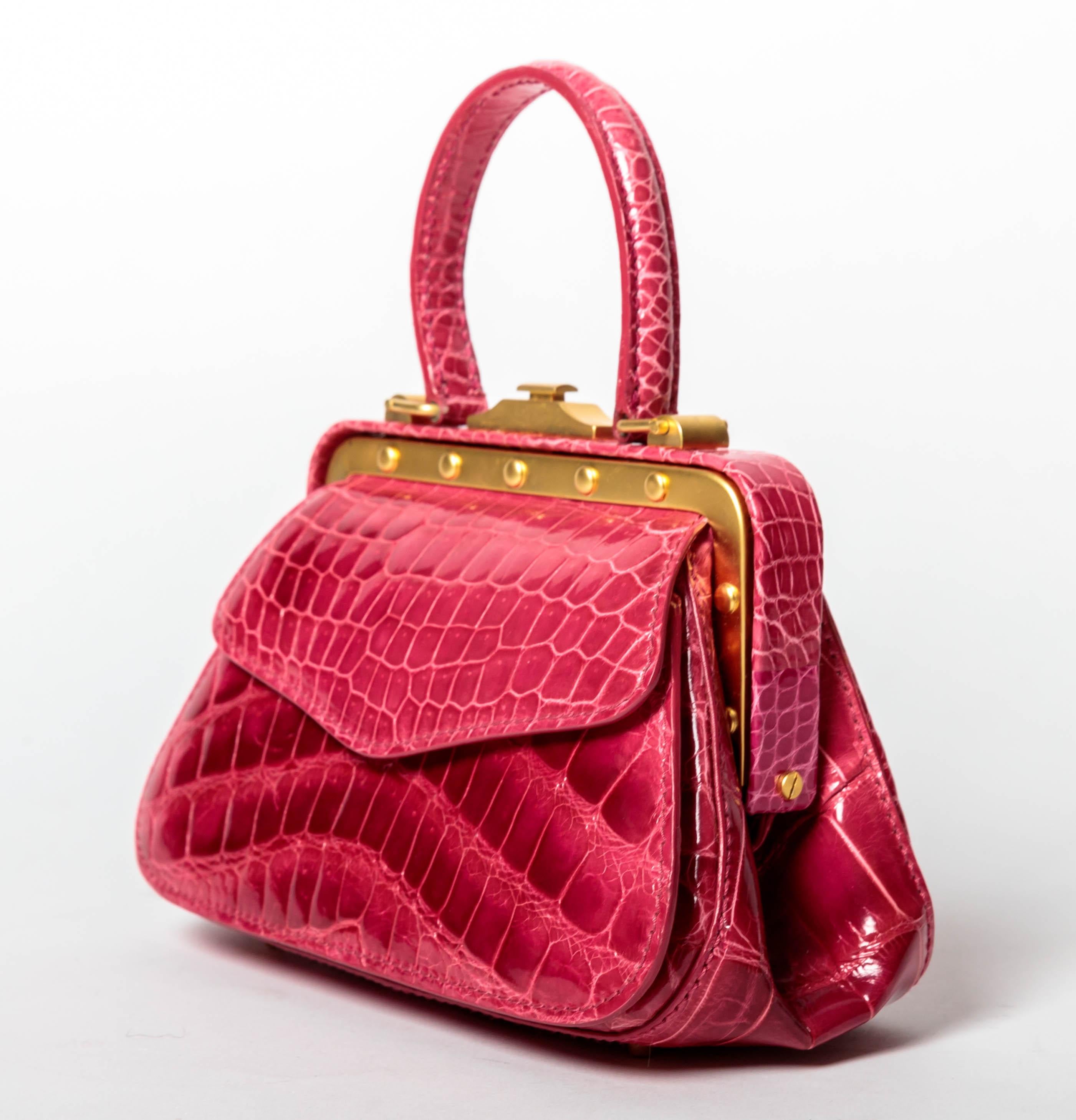 Charming Pink Crocodile Suarez Handbag with Front Snap Pocket, Detachable Crocodile Shoulder Strap and Interior Zip Pocket
Condition is Excellent
Satin Finish Gold Hardware
Shoulder Strap Drop 22 Inches /  47 Inches From End to End