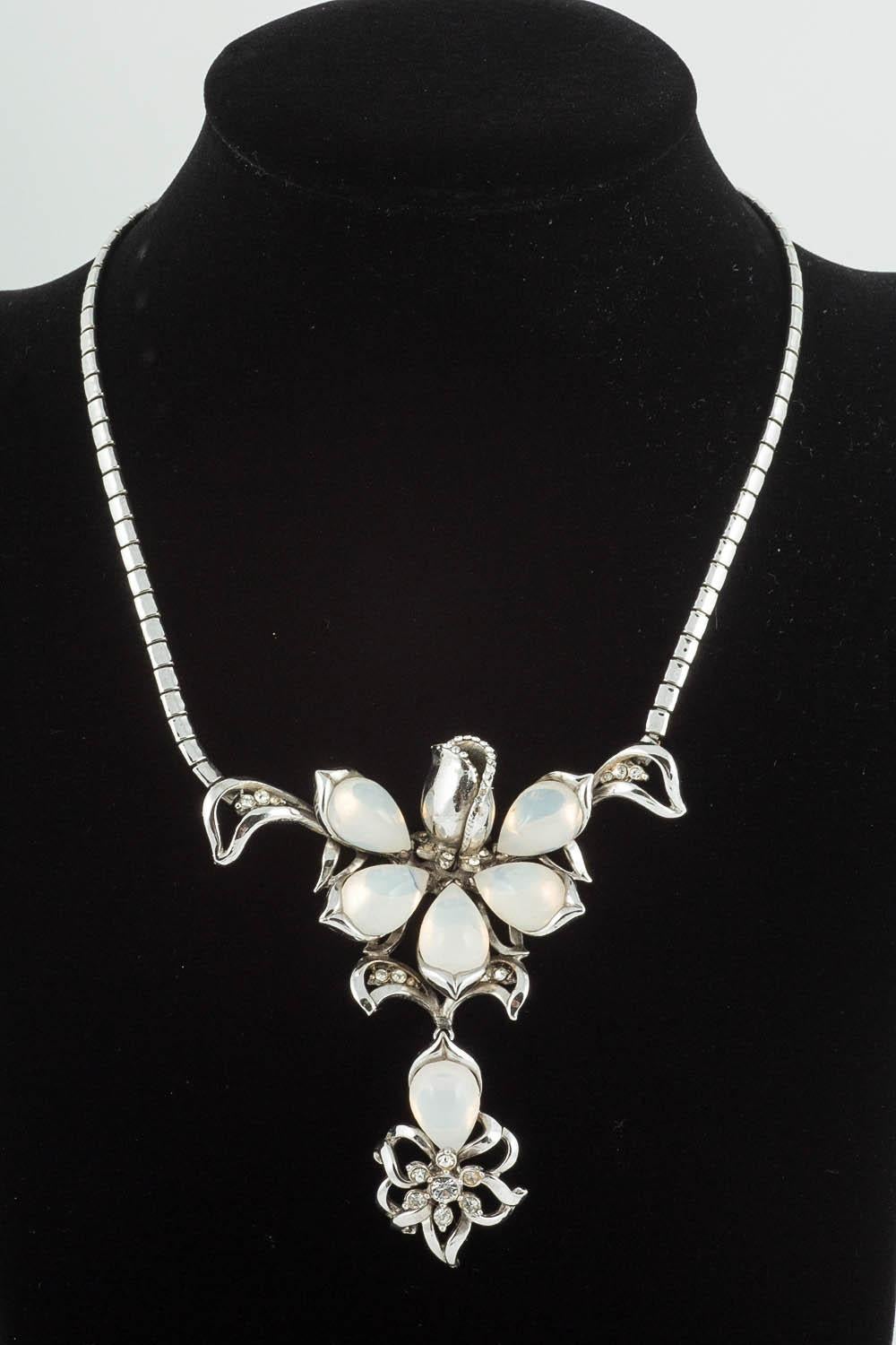 This highly stylised and elegant parure consists of a necklace, brooch, bracelet and matching earrings. Cast and created through the lost wax process, this gives grater clarity and sharpness to the design, which is of a stylised flowerhead, the