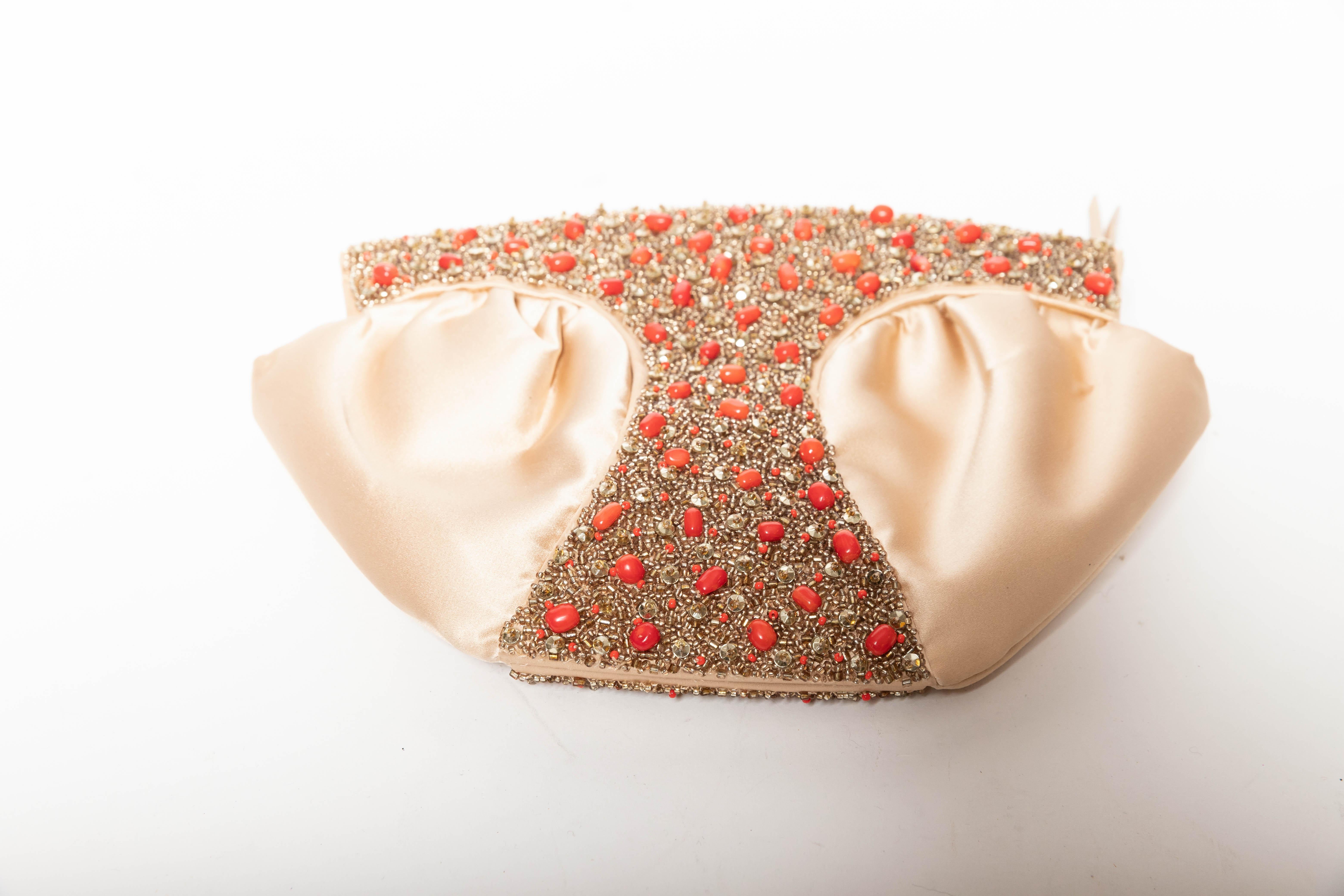 Champagne silk Oscar de la Renta clutch with zip top.
Coral and champagne beads adorn the front and back of this beautiful piece.
One inside zip pocket.