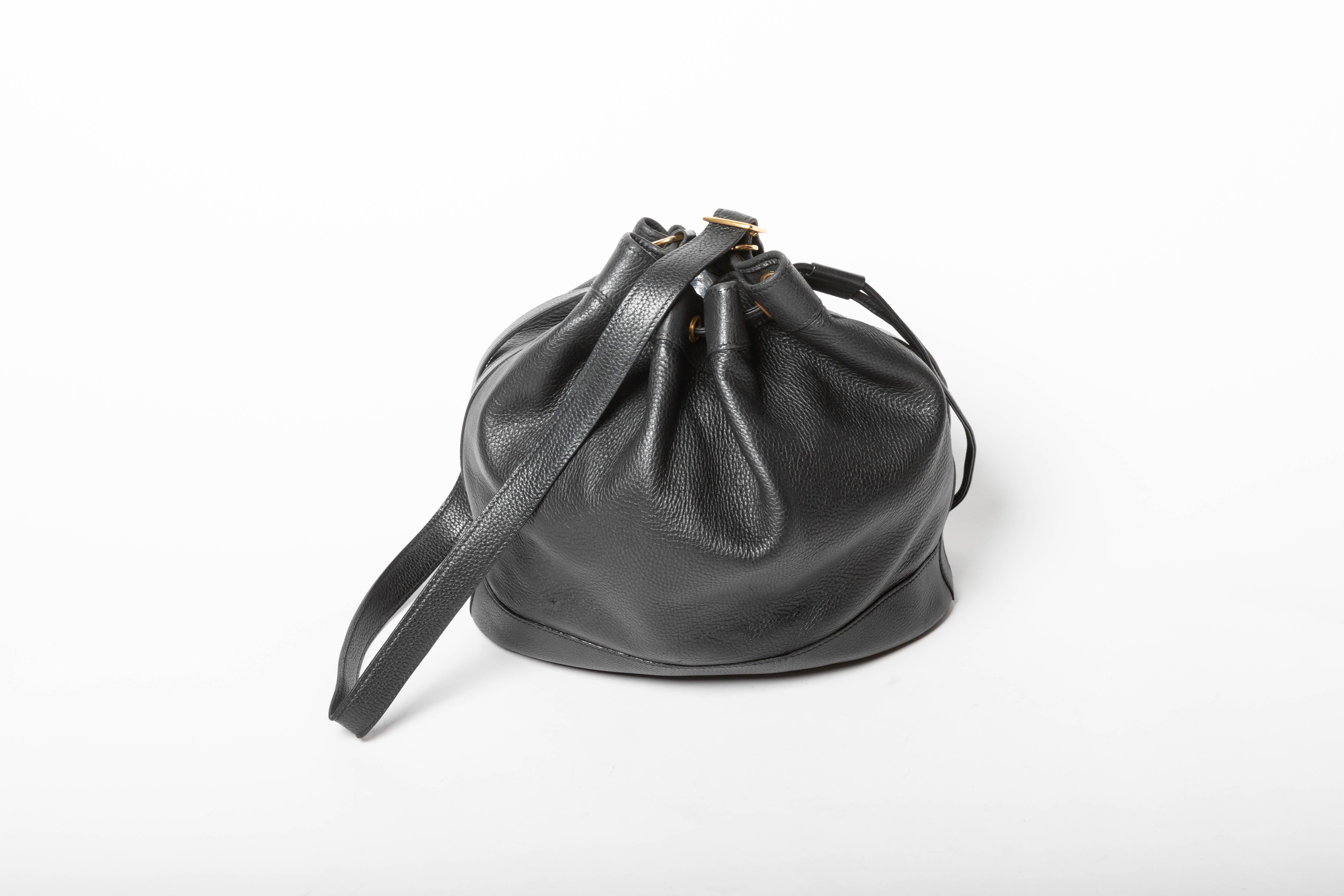
This amazing Hermes bucket bag is in very good condition. The exterior features beautiful black leather trimmed with a gold buckle along the shoulder strap. The drawstring style closure opens to an unlined leather interior with enough storage space