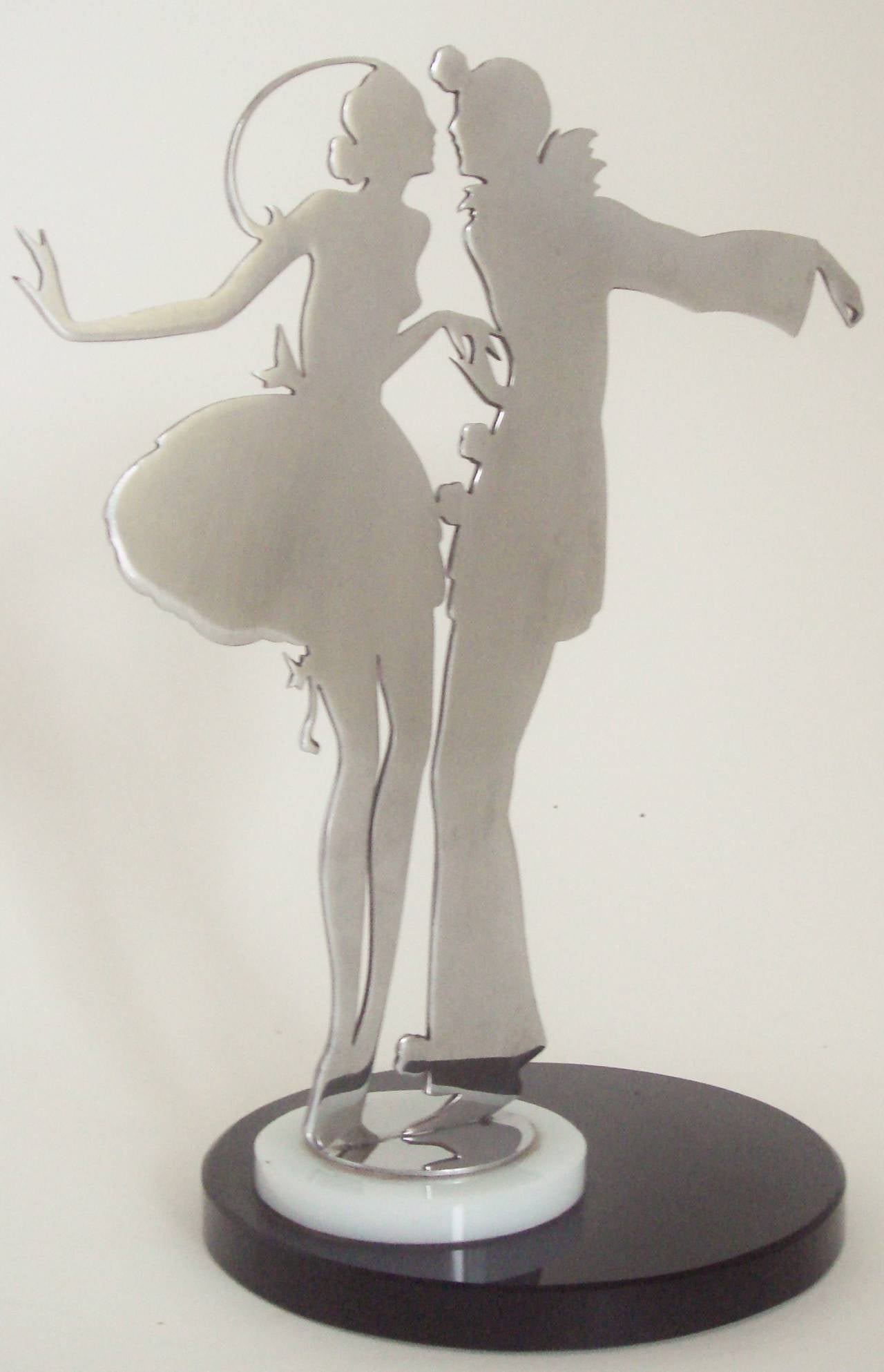 This fabulous French Art Deco jewelry store display stand features a beautifully delineated chrome Silhouette of Pierrot and Pierrette, both with their arms extended and their lips about to touch. The fingers of Pierrot's left hand are fashioned to