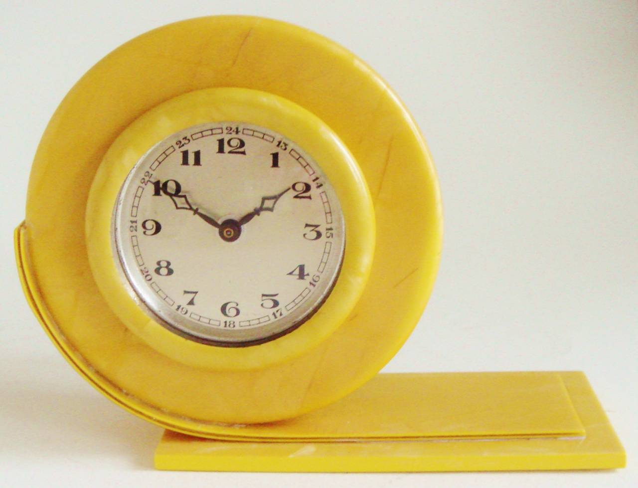 This beautiful little asymmetrical mechanical English Art Deco shelf clock is fashioned in bright yellow and marbled pearlescent celluloid. The clock is in fine and totally original condition with no discolouration, chips, cracks or scratches to the