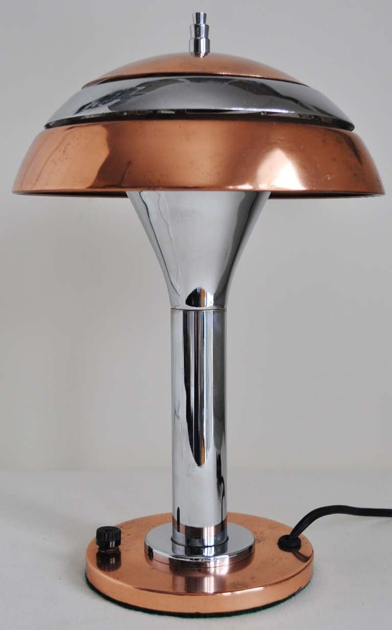 Cette magnifique petite lampe d'appoint américaine Art Déco chromée et cuivrée conserve son interrupteur d'origine en bakélite à la base. L'abat-jour strié/segmenté permet de filtrer la lumière pour un effet maximal. La lampe a été polie et recâblée.