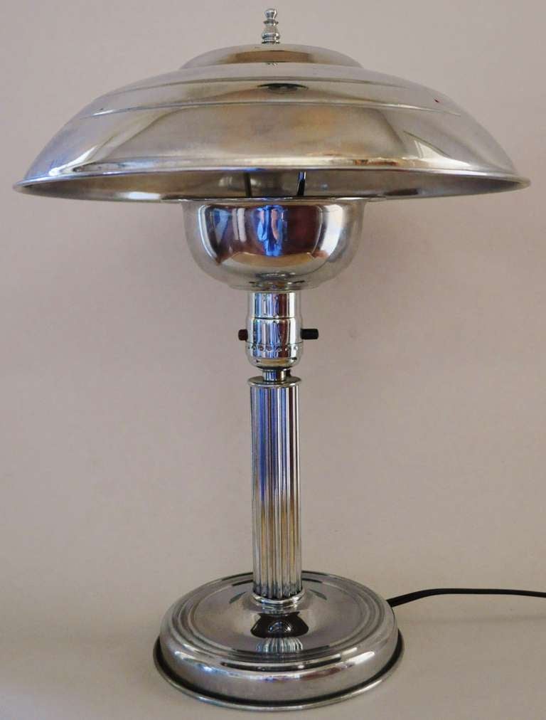 This medium size pair of American Art Deco polished aluminium and chrome plated metal table or bedside lamps feature fluted columns and an under the socket cup diffuser. They are both in excellent condition and have been rewired for safety.