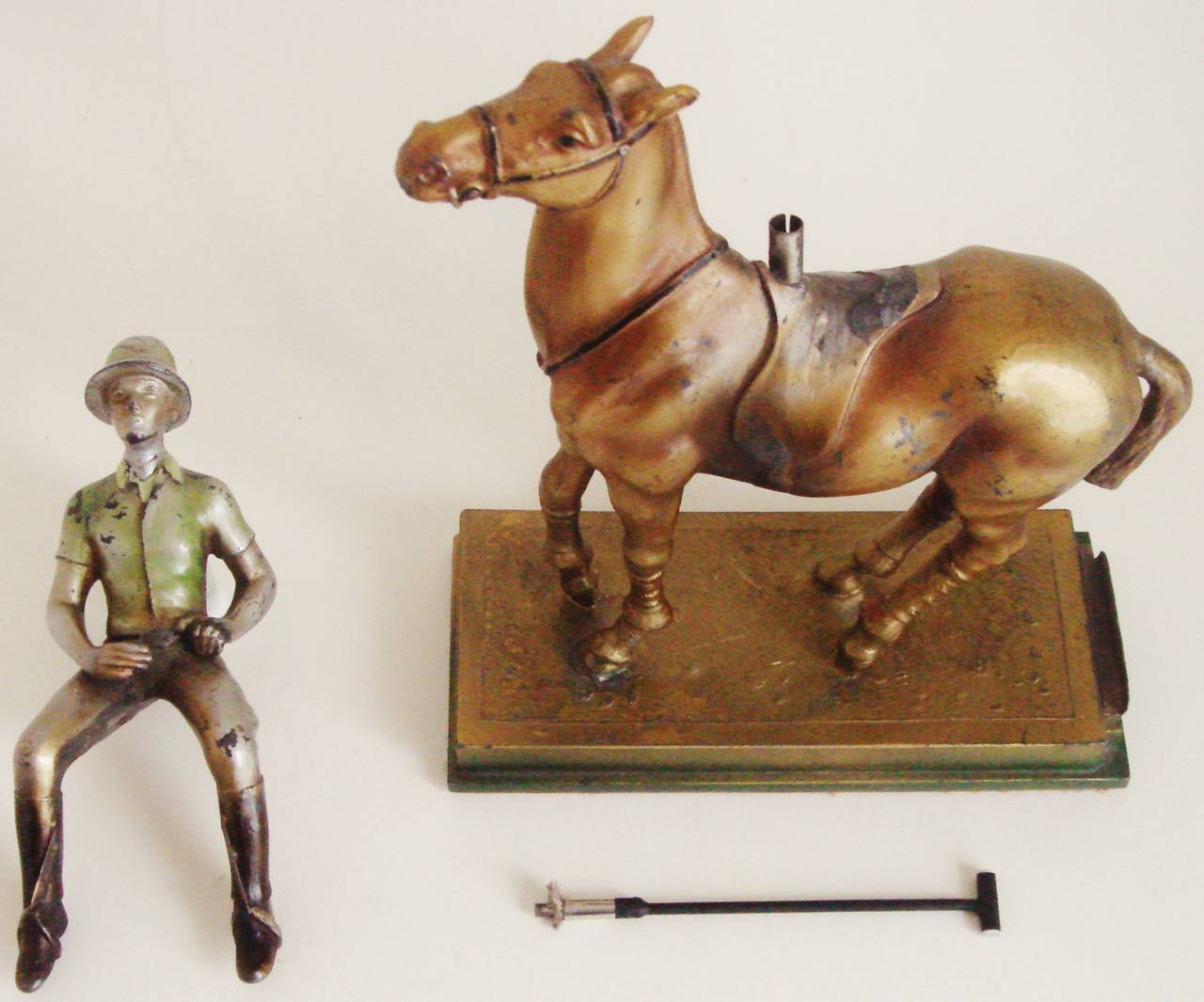 This rare Austrian Art Deco figural table lighter is in cold painted spelter (zinc alloy) and takes the form of a mounted polo player. The rider's polo mallet can be withdrawn from the pommel of the rider's saddle to reveal the striker wand and the