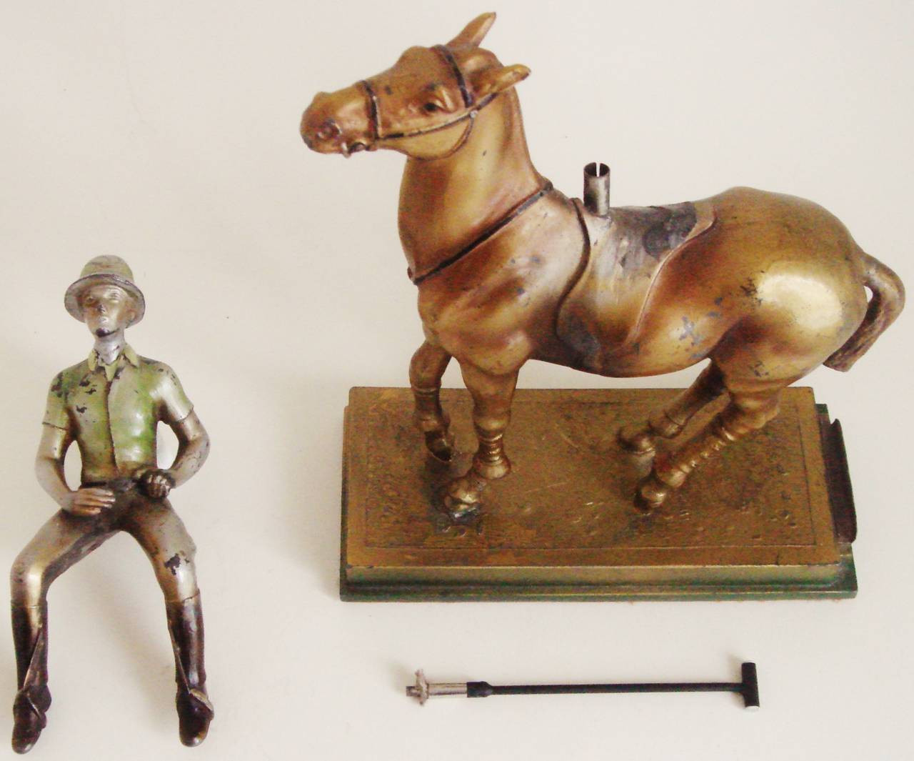 This rare Austrian Art Deco figural table lighter is in cold painted spelter (zinc alloy) and takes the form of a mounted polo player. The rider's polo mallet can be withdrawn from the pommel of the rider's saddle to reveal the striker wand and the