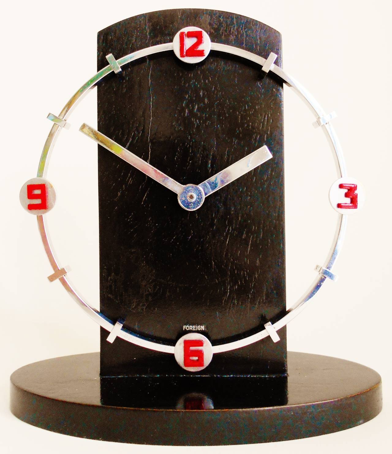 This stunning German Art Deco shelf clock features a ring of original chrome plated metal. This displays each of the quarter hour numerals in red enamel and backed by small chrome disks with the other numerals represented by small chrome bars. The