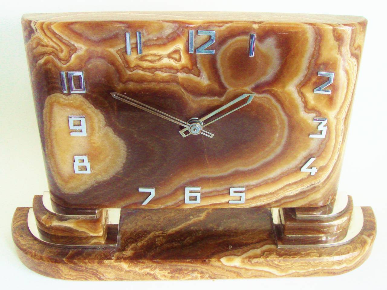 This beautiful Classic Art Deco mantel clock is constructed from solid polished variegated gold onyx that ranges in color from chocolate brown to ivory. The onyx is blemish free save for a very small chip to the rear corner of the clock, camera