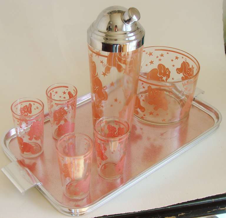 This American mid-century six piece Pink Elephant cocktail set consists of a chrome capped glass shaker (10