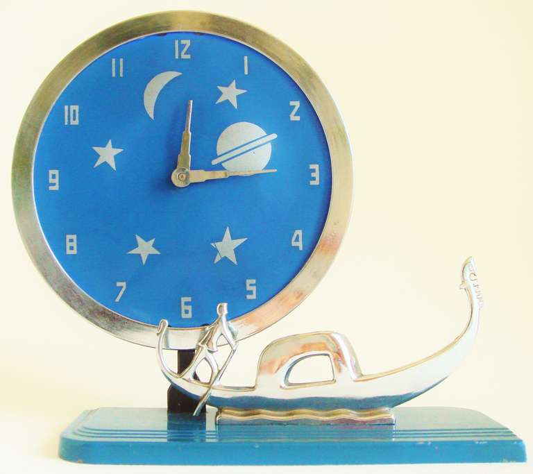 This is a rare variation of Frank Mariani's Iconic circular clock design for Die Casters of New York. A chrome plated stylized gondola floats on the usual Die Caster's base enamelled in a deep blue. The chrome plated bezel of the clock is mounted on