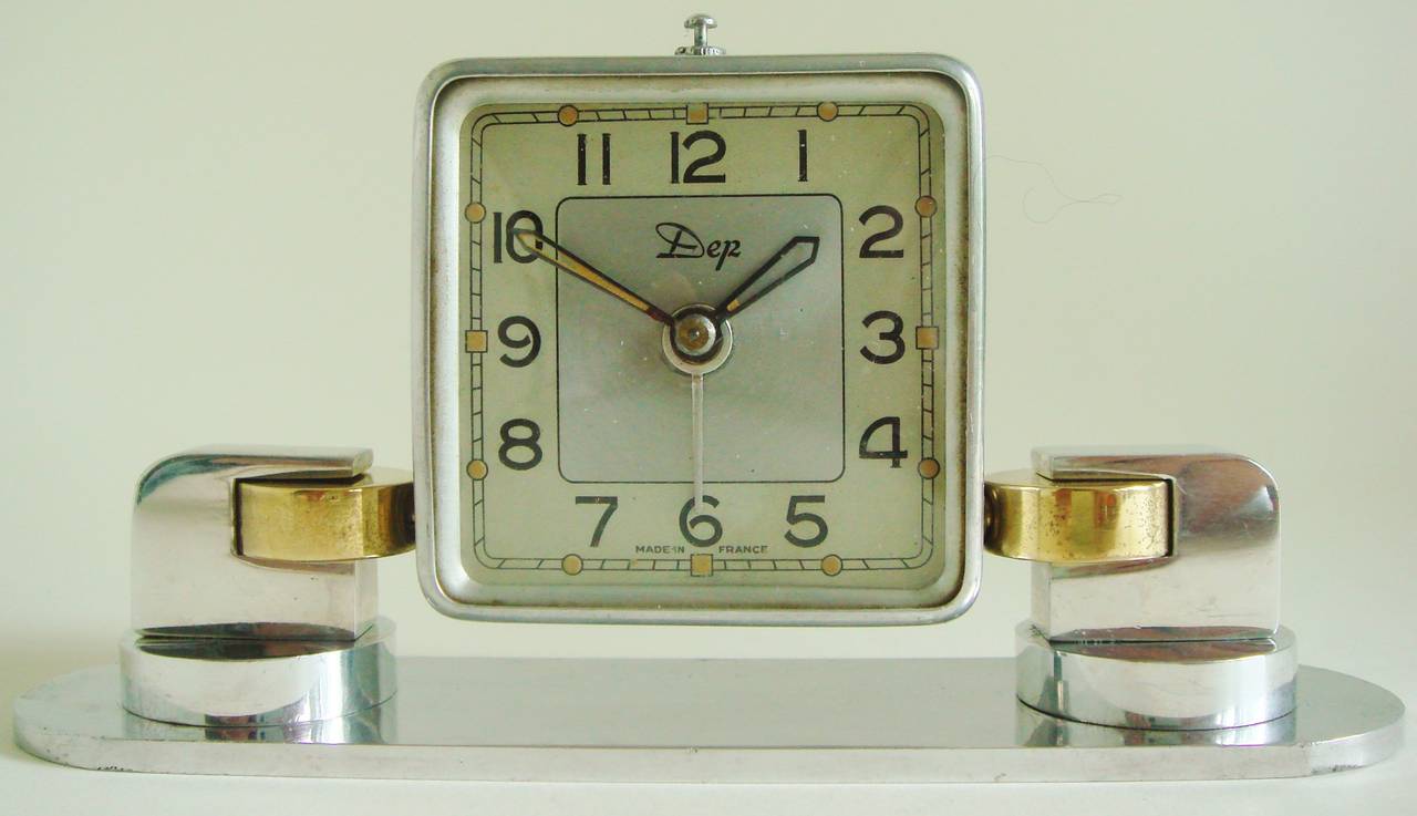 This lovely little French Art Deco mechanical tilt alarm clock is in highly polished aluminium with brass accents. We have previously sold a more basic model of this same Dep clock on 1stdibs but it was totally in brushed aluminium and with no