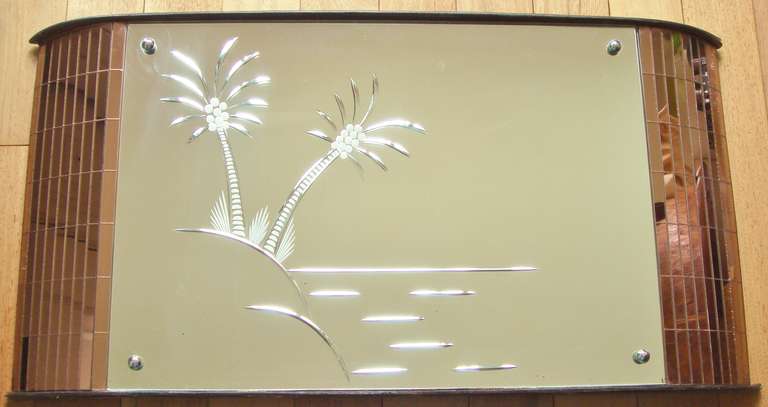 This Art Deco mirror was probably designed to hang over the mantelpiece and enable its owner to gaze up at the wheel-cut and etched palm trees and dream of sunny drenched days on a tropical island. (As he or she huddled over their  coal fire in the