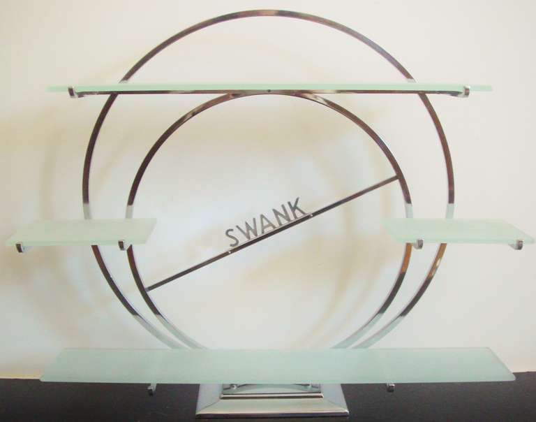 This fabulously styled American Art Deco chrome and frosted glass piece was designed to display the men's jewellery and accessories produced by The Swank Company of Attleboro, Massachusetts in the 1940's. The Swank wordmark in sans serf caps type on