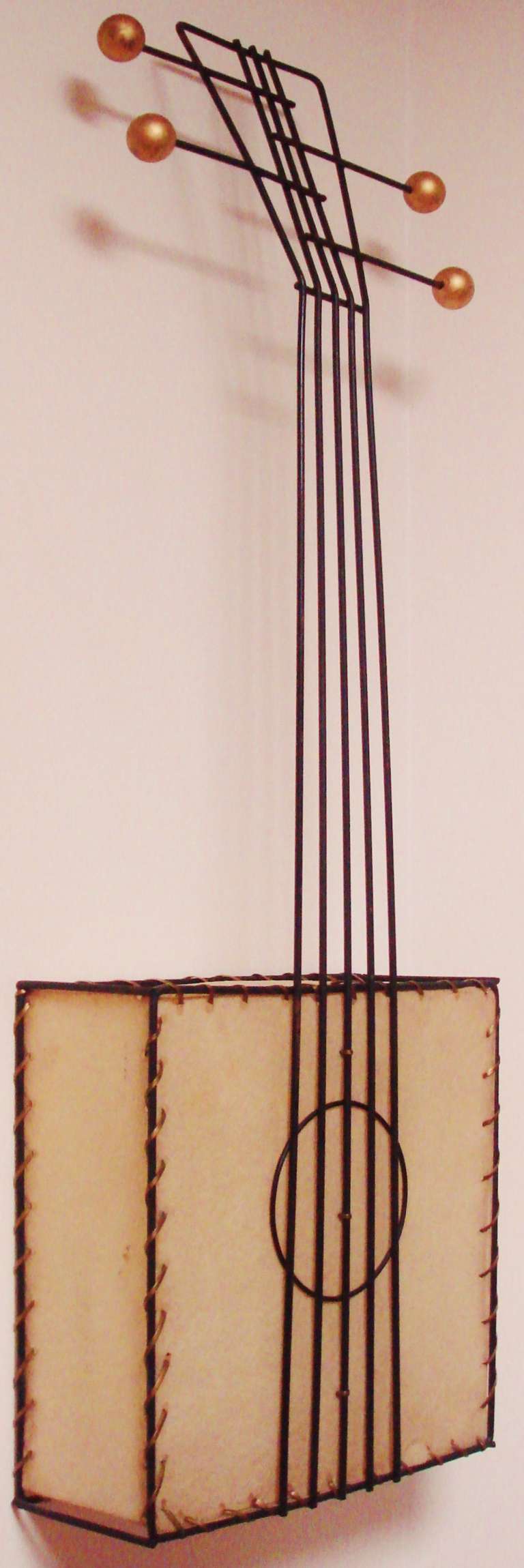 This iconic American Mid-Century Modern figural square guitar wall lamp by Frederick Weinberg is one of a series of 5-stringed instrument lamps that he created for his interior accents company, The Frederick Weinberg Company of Philadelphia. This