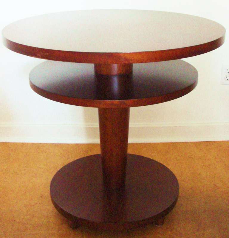 This exquisitely designed American Art Deco Revival entry hall table is veneered on a rich Brazilian Rosewood. Its circular top, shelf and and base plate are each sunburst veneered and descend in diameter as they themselves descend down the tapered