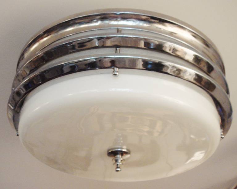 This American Art Deco/Machine Age Markel triple-banded flush mounted ceiling light is believed to be an example the largest version of this design of ceiling lamp that the company made. Both the chrome plate and the milk glass are in fabulous