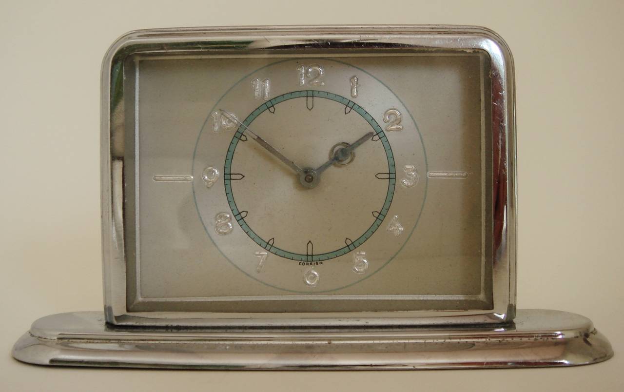 This delightful small German Art Deco desk clock has all original and near perfect chrome both front and back. The stunning ultra Art Deco style graphics on the face are almost mint as are the geometrically designed hands. The word 'Foreign' is