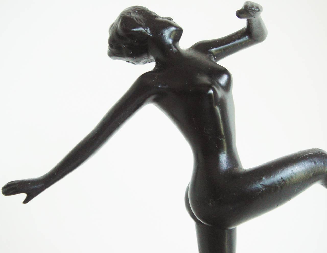 This fabulous English Art Deco chrome and black figural striker table lighter incorporates an ebulliently prancing nude female figure by Lorenzl enamelled in black. She stands on a chrome disk base in front of a hexagonal chrome pillar that holds