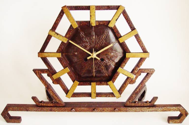 This stunning geometric wrought iron French mantel clock features hammered detailing with brass washed accents. The original mechanical movement has been replaced at sometime during the last century with a clear Lucite German battery movement which