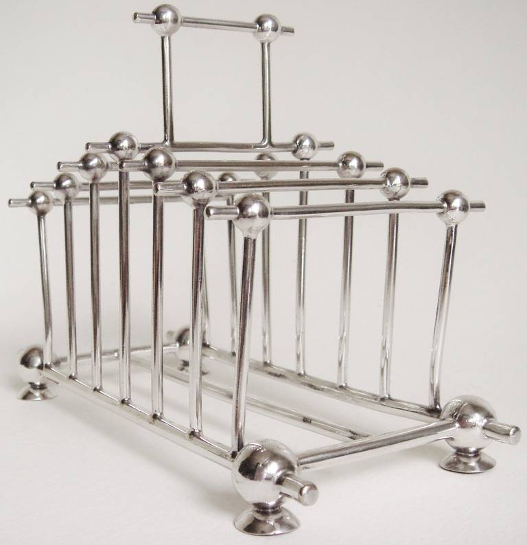 This English Aesthetic Movement toast or letter rack is designed in the distinct style of Christopher Dresser and, as a result, is often attributed to him. It bears the hallmark of Richard Richardson, a firm of silversmiths that was established in