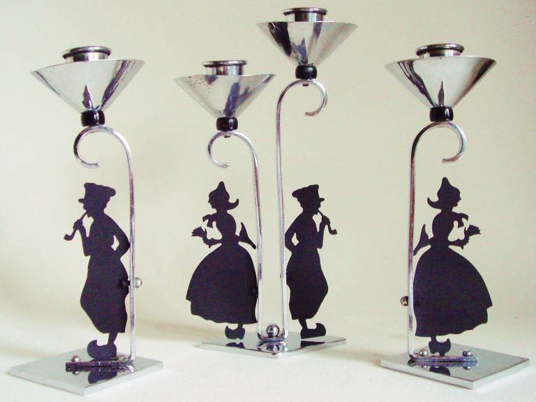 This great set of three chrome-plated figural English Art Deco candleholders features black enamelled silhouettes of traditionally dressed Dutch boys and girls delineated in the distinctive style of Lotte Reiniger (1899-1981). Reiniger's animated