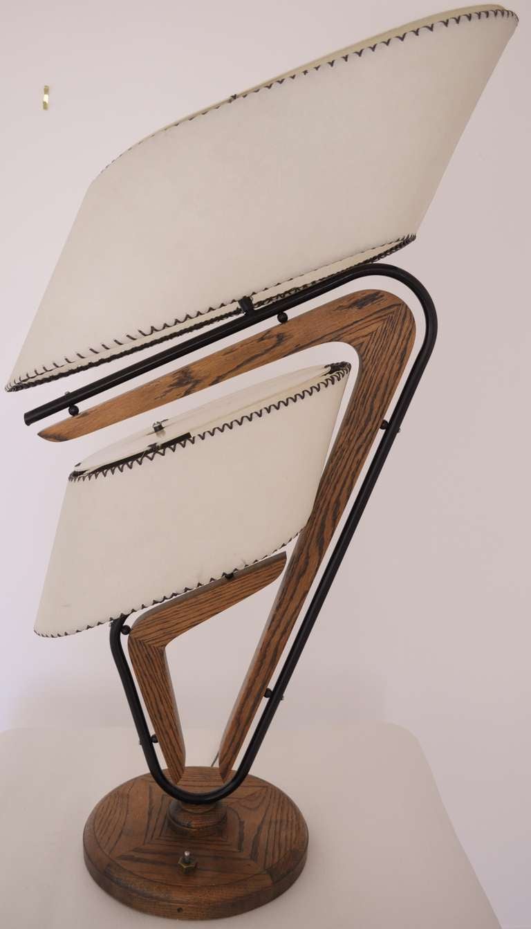 This incredible pair of iconic American Mid-Century Modern Majestic Deluxe 260 twin branch Boomerang Table Lamps both have solid walnut bases, black enameled tubing, brass plated accents and asymmetrical whip-stitched fiberglass shades. These are