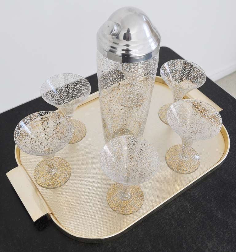 This wonderful American Mid-Century Modern martini set by Hazel Atlas features the beautiful and seldom seen Golden Snowflake pattern. Six of their large size martini glasses are paired with a extra tall shaker with a polished aluminium top. The