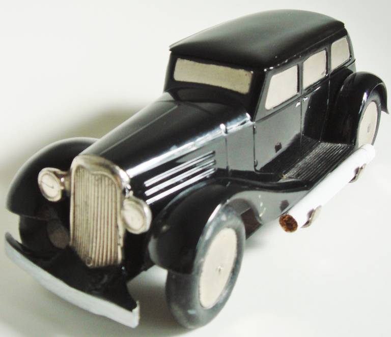 This beautiful and very rare German inter-war figural miniature car mechanical cigarette dispenser is designed after a limousine of the period (Model unknown but similar to the late 1930s Packard models with suicide doors). The roof of the car is