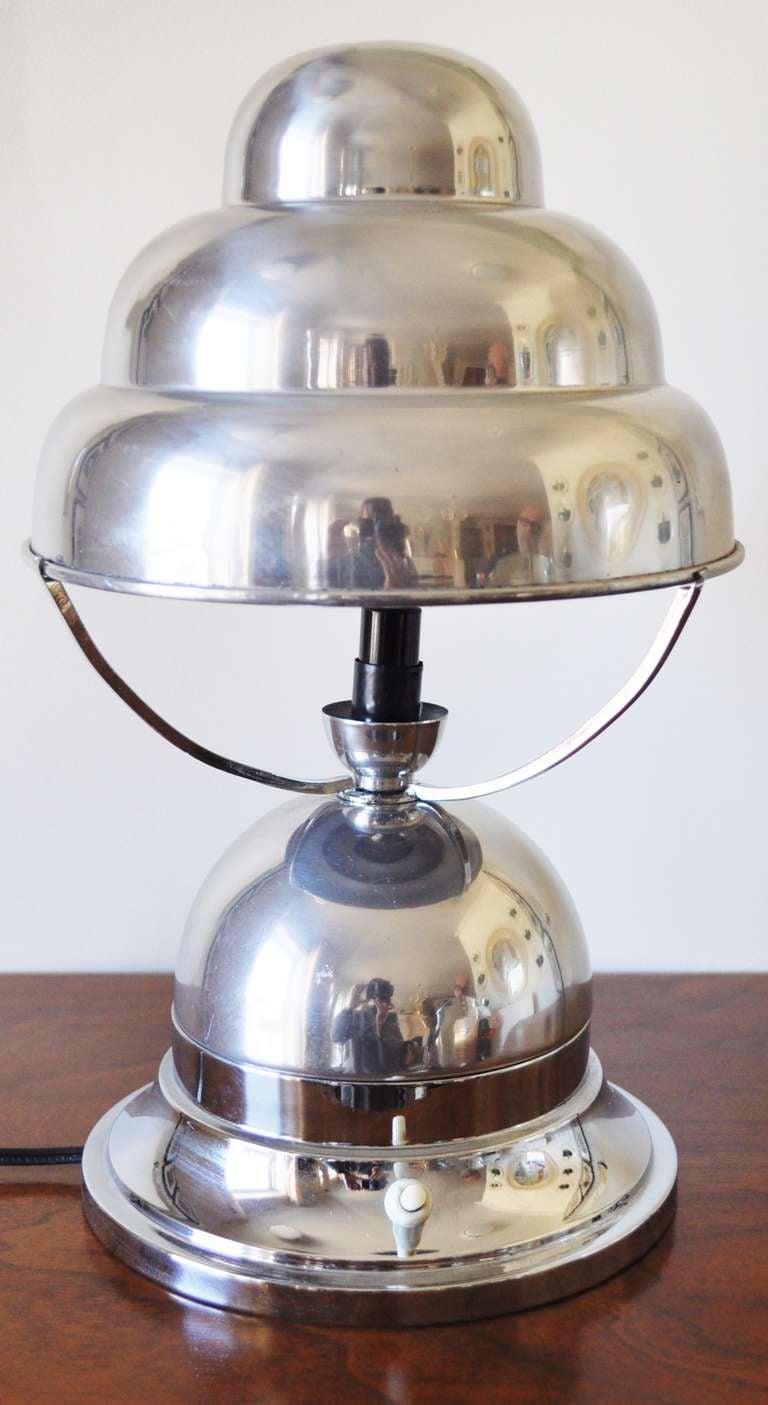 This French Art Deco Aluminum table lamp has often been referred to as the Bibendum lamp for obvious reasons. The three part shade bracket is made from chrome plated brass, the lamp has been rewired and the original white plastic push switch has