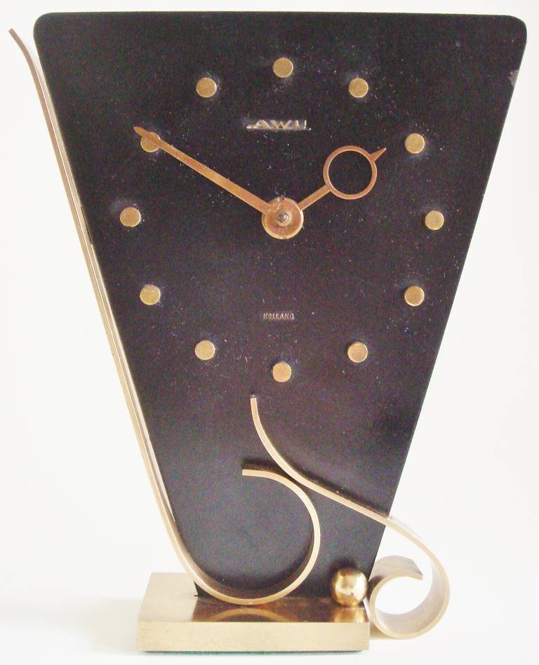 These three iconic clocks are from a series of eccentrically styled triangular clocks by Amsterdam School designer, Johannes Bosma (1879-1960) in the 40's and 50's. The base, numerals and hands are in brass and the body of the clocks in flat black