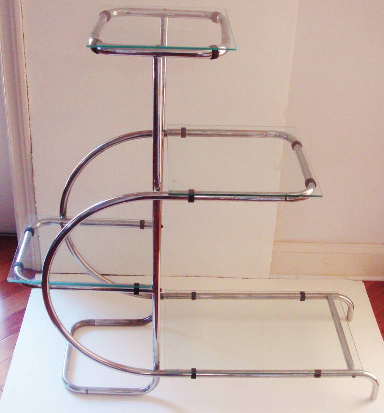 These fabulously designed German Art Deco Bauhaus chrome and glass, four tier, free-standing display shelves were imported into Canada in the mid-1930s. They were used in various areas of the extreme Art Deco designed Eaton's College Street