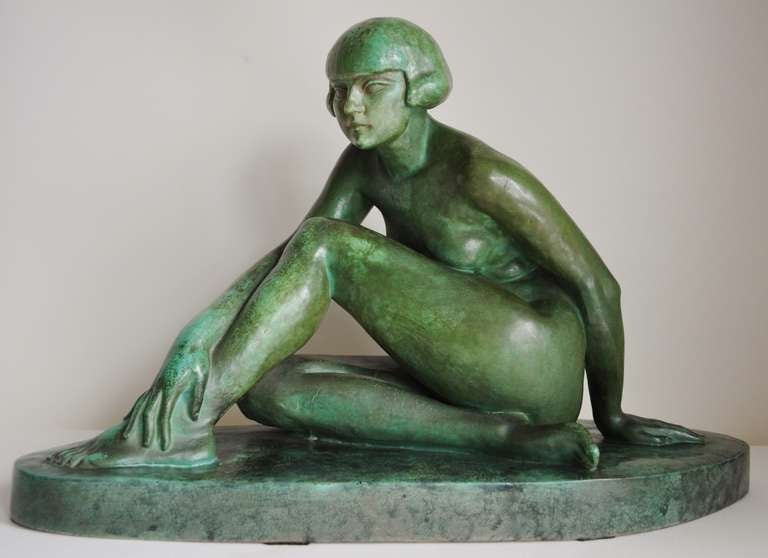 Grande figure/sculpture en céramique Art déco française représentant un nu féminin assis avec des cheveux bouclés. La figure est émaillée pour ressembler à du cuivre avec une patine verte tachetée et la base est émaillée pour ressembler à du marbre.