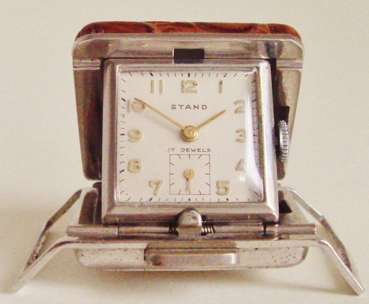 This beautiful and compact spring-loaded American Mid-Century Modern Chrome and faux crocodile watch was designed for the sportsman/woman. It could be used as a desk clock and then perhaps threaded on to a belt for use on the golf course. Checking